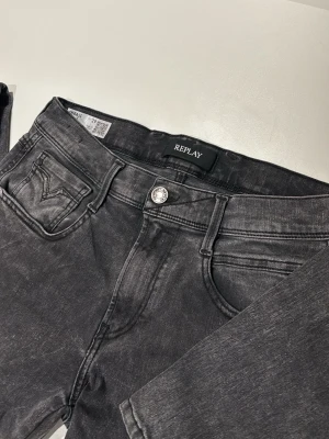 Svarta Replay jeans - Snygga svarta jeans från Replay med tvättad finish och klassisk femficksmodell. Jeansen har raka ben och silverfärgad knapp framtill. Materialet är mjukt denim som ger en avslappnad vibe. Perfekta för dig som gillar en stilren men ändå cool look.