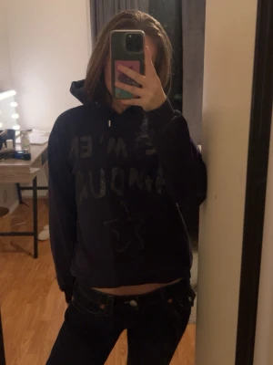 Mörkblå hoodie med tryck och huva - Mörkblå hoodie med huva och tryck framtill där text och en stjärna syns. 