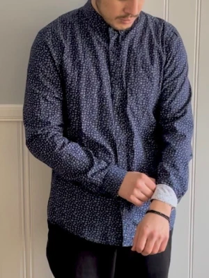 Blå blommig skjorta från Selected Homme - Snygg blå skjorta från pull&bear med små vita blommor över hela tyget. Skjortan har klassisk krage, knäppning framtill och långa ärmar. .