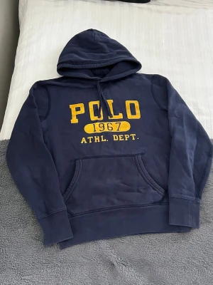 Polo Ralph Lauren Hoodie - Säljer denna snygga Ralph Lauren hoodie i fint skick. Hoodien är storlek XS. Längd: 60cm, Bredd: 48cm, Axelbredd 45cm, Ärmlängd: 57,5cm.