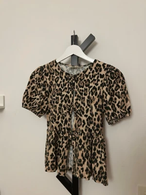 Leopardmönstrad blus med knyt - Leopardmönstrad blus med rosetter. Storlek 158/164