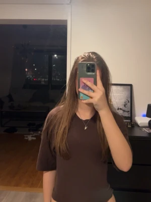 Brun omlottopp med knyt i ryggen - Säljer en brun topp med korta ärmar och omlottdesign som knyts i ryggen. 