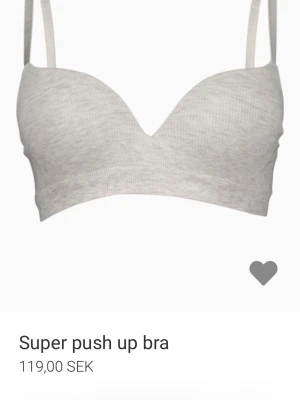 Newyorker push up-bh - Trendig ljusgrå push up-bh med vadderade kupor och justerbara axelband. Bh:n har en mjuk ribbad yta och ger extra lyft och form. Perfekt för dig som vill ha en bekväm och snygg bh med extra push.