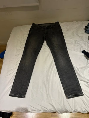 Svarta slim fit jeans - Säljer ett par svarta slim fit jeans med klassisk femficksdesign och dragkedjegylf. Jeansen har en lätt tvättad look och raka ben. Perfekta till en avslappnad grisch-stil.