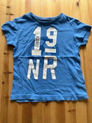 T-shirt - T-shirt för barn med tryck på framsidan. Trycket har börjat krakelera lite 