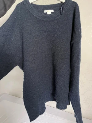 Mörkblå stickad tröja Gina Tricot - Mysig mörkblå stickad tröja från Gina Tricot med avslappnad passform och rund halsringning. Tröjan har långa ärmar och ribbstickade muddar vid halsen. Perfekt för kyliga dagar och enkel att matcha med olika outfits. Tröjan är använd några få gånger, inga skador syns❤️(Vet inte vad nypriset är så säljer för 100kr)
