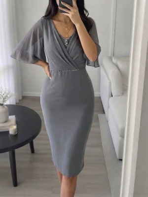 Fest klänning  - Säljer nu denna otroligt smickrande och eleganta klänning i en vacker duvgrå/gråblå nyans. Perfekt för bröllopsgäst, dop, examen eller andra festliga tillfällen! Storlek 50, men den är som en 44/46. Använd vid ett tillfälle endast så den är som ny och tyvärr passar den inte längre. Köpt för 3500.