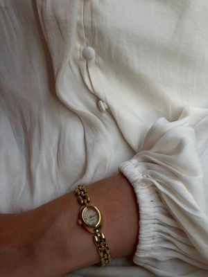 Guldfärgad klocka från Muli Collection - Elegant klocka från Muli Collection. perfekt för dig som gillar klassiska accessoarer med en lyxig touch. Säljer pga fått dubbletter i födelsedagspresent🥹🫰🏻nypris 1900kr mitt pris 1500kr.