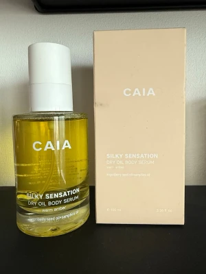 CAIA Silky Sensation Dry Oil Body Serum - Silky Sensation Dry Oil Body Serum från CAIA med doft av warm amber. Kommer i en rund glasflaska med vit pump och tillhörande beige kartong. Innehåller lingonfröolja och samphiraolja. Perfekt för dig som vill ha en återfuktande kroppsolja med lyxig känsla.