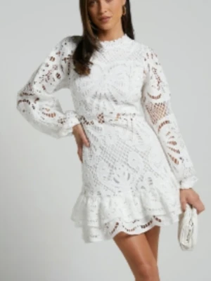 KISS ME NOW student/ midsommar/ fest spetsklänning med volang M - Superfin vit kort klänning i spets med långärmade puffärmar och volangkant nedtill. Klänningen har hög hals och ett detaljerat broderat mönster som ger en romantisk vibe. Perfekt för sommarens alla tillfällen.