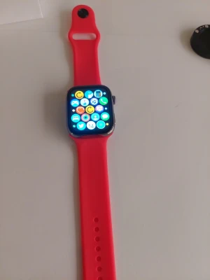 Smartklocka med rött silikonarmband - Snygg smartklocka med fyrkantig svart urtavla och ett starkt rött silikonarmband. Klockan har en stor touchskärm där du enkelt kan navigera mellan appar och funktioner som kalender och notiser. Perfekt för dig som vill ha koll på allt direkt på handleden.