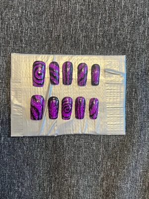 Press-on naglar || Storlek M - Snygga press-on naglar i lila med svart swirl-mönster och glittereffekt. Naglarna har en rak, något rundad form och cool design som sticker ut. Perfekt för dig som vill ha en unik och trendig look. Storlek M, Det du får med dig : * Fil och manikyr pinne * nagellim klistermärken * 2 lappar av rengöring för naglar.