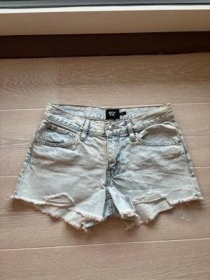 Ljusblå jeansshorts från 157 - Snygga ljusblå jeansshorts från 157 med fransig kant och slitna detaljer framtill. (Oanvända) 