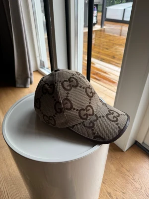 Gucci Brown GG Hat - Säljer en Gucci keps i väldigt bra skick lite missfärgningar på själva bandet som sitter runt huvudet men inget som syns när du väl har på dig den.  Köpt från Gucci butiken alla tillbehör följer med såsom tags box osv!  Storlek L (58cm)  Nypris runt 5 tusen!
