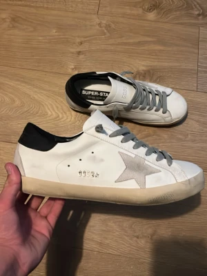 Vita sneakers med grå stjärna - . Litet täcken på användning en liten liten röd fläck som knappt syns annars är dem riktiga och säljs för endast 2899. Hör av er vid minsta lilla fråga