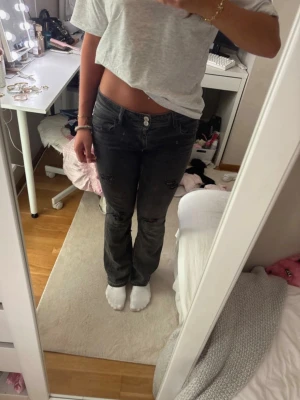 Svarta bootcut jeans med slitningar - Säljer dessa lågmidjade jeans köpta från Gina i storlek 164, har själv gjort hålen och är sprättade nertill. Passar perfekt på mig som är 171