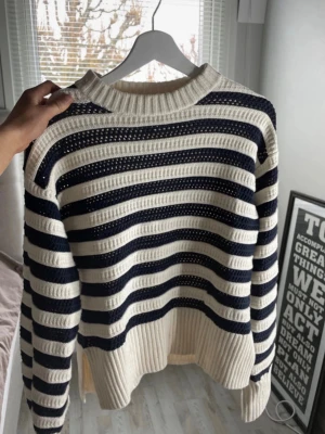 Randig stickad tröja från H&M - Supersöt stickad tröja från H&M i storlek XS. Tröjan har breda marinblå och vita ränder, rund halsringning och ribbade muddar. Oanvänd. Pris kan diskuteras.
