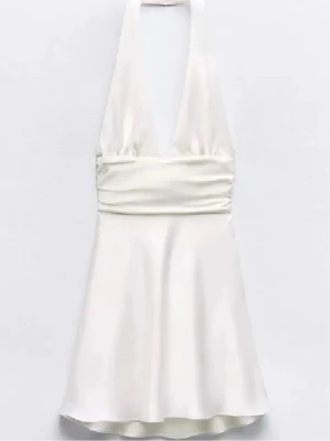 Vit halterneck klänning i satin - Supersnygg vit kortklänning perfekt till studenten i satin med halterneck och djup v-ringning. Har en dragkedja på sidan av den för lättare på/av.  Den är ifrån Zara men köpte här på plick och säljer därav jag tyckte den var för kort på mig. Den är i storlek M!! Skriv för frågor eller fler bilder🤞