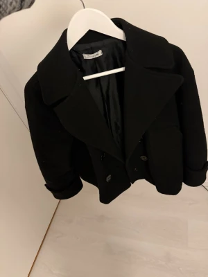 Svart kort kappa - Svart kort kappa från designbysi i storlek xs/s