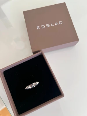 Silverring  Edblad - Snygg silverfärgad ring från Edblad med blanka, infattade stenar på ovansidan. Ringen har en stilren och modern design som passar perfekt till dig som gillar minimalistiska smycken. Levereras i originalask från Edblad.