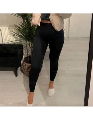 Svarta ribbade leggings - Svarta leggings med ribbad struktur och hög midja. De är tighta och har en enkel, stilren look som passar perfekt till en avslappnad outfit. Materialet känns mjukt och stretchigt, vilket gör dem bekväma att bära hela dagen. Passar xs och s, då de är väldigt stretchiga av sig. 