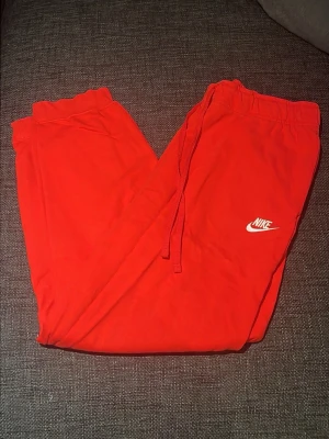 Nike sweatpants - Säljer ett par röda Nike byxor. Bra skick, inget sönder. Storlek: XL i barnstorlek men sitter som M i vuxenstorlek.