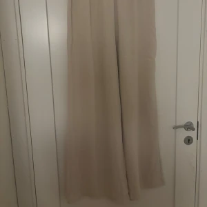 Beiga vida linnebyxor med resårmidja - Snygga beiga linnebyxor med breda ben och resår i midjan. Perfekta för en avslappnad och trendig stil. Luftigt material som känns skönt mot huden och passar till många olika outfits.