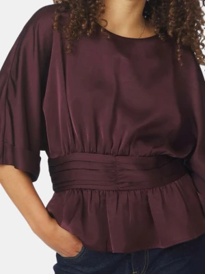 Vinröd blus, neo noir. Aldrig använd. Köpt för 699 säljer för 299 - Snygg plommonlila blus med bred markerad midja och volang nedtill. Blusen har rund halsringning och trekvartsärmar med breda manschetter. Tillverkad i ett glansigt, mjukt material som ger en lyxig känsla. Perfekt att styla med jeans eller kjol.