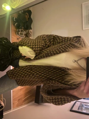 Brunmönstrad oversized cardigan - Säljer en oversized cardigan med brunt och beige rutmönster. Jackan har en avslappnad passform, långa ärmar och öppen front. Perfekt att slänga över en t-shirt eller stickad tröja för en chill look.