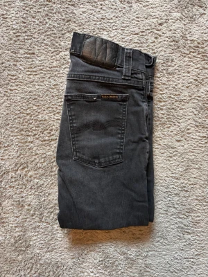 Nudie Jeans  - Nudie jeans slim  jeans, storlek W29 L32. Begagnade men i bra skick – inga fläckar, revor eller blekta delar. Använda ca 5-10 gånger. Midjemått 36 cm, innerbenslängd 77 cm & byxlängd 100 cm. Slim fit passform! Autentiska såklart. Fri frakt inom Sverige. Nypris: 1299kr