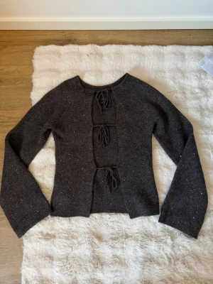 Mörkbrun glittrig stickat tröja med öppen rygg - Använd 1-2 gånger , i nyskick! Väldigt fin! Stl M 14+ från Gina Young 