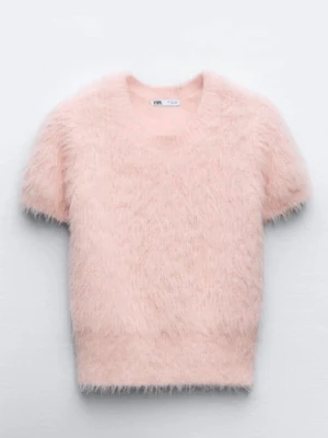 Ljusrosa fluffig stickad topp Zara - Supersöt ljusrosa stickad topp från Zara med korta ärmar och rund hals. Tröjan är gjord i ett fluffigt, mjukt material som ger en trendig och mysig look. Perfekt att styla med höga jeans eller kjol för en cool vibe.