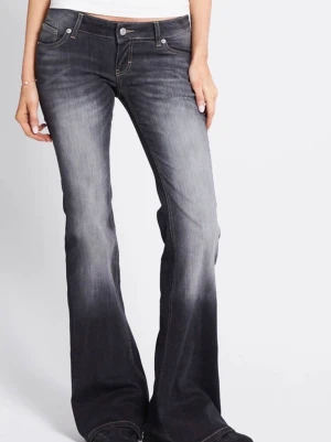 Svarta bootcut jeans med slitningar - Säljer ett par svarta bootcut jeans med snygga slitningar och ljusare tvätt på låren. Jeansen har klassisk femficksmodell, låg midja och kontrastsömmar. Perfekta för en trendig och avslappnad stil. 275 kr + frakt 