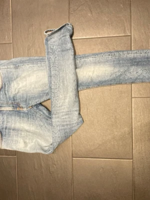 Vintadge Nudie jeans  - Säljer ett par ljusblå slim fit jeans med klassisk femficksdesign och snygga slitningar på bakfickorna. Jeansen har normal midja och smal passform hela vägen ner. Perfekta för en avslappnad och trendig look. Kontakta vid frågor!
