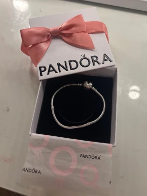 Pandora silverarmband 18 cm💕 - Snyggt silverfärgat armband från Pandora med klassiskt ormkedjemönster och ett hjärtformat lås där Pandora-loggan är ingraverad. Perfekt för att samla och bära olika berlocker. Säljer eftersom den var för stor💕Går absolut att diskutera priset💗