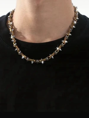 Titanium steel Kedjehalsband med silverfärgade nitar - Säljer ett chunky halsband i guldtonad metall med silverfärgade konformade nitar längs hela kedjan. Halsbandet har en edgy och modern vibe, perfekt för att lyfta din outfit. Låset är diskret och designen är riktigt statement.