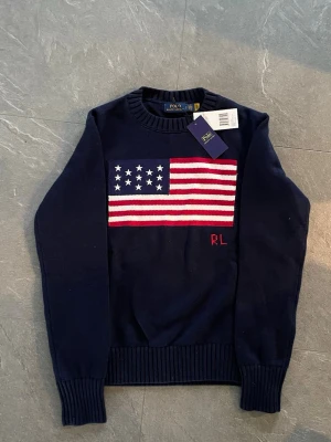 Mörkblå stickad tröja Polo Ralph Lauren - Döfet ”USA” tröja från Ralph Lauren. Storlek S, Jag är 180 och 70kg, den passade för litet på mig. Helt ny. Aldrig använd! Hör av er vid minsta lilla fundering. Priset är ej fast!😆