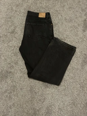 weekday space relaxed - Säljer ett par svarta jeans från Levi's med rak passform och klassisk femficksdesign. Jeansen har en läderpatch bak i midjan och är tillverkade i kraftig denim. Perfekta för en stilren och avslappnad look.