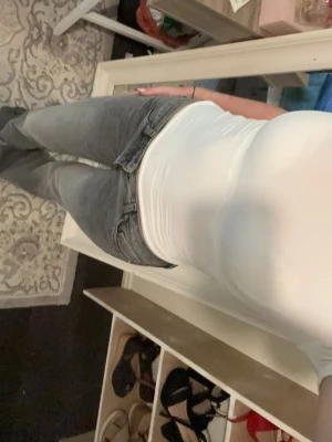 Grå bootcut jeans med låg midja - Snygga grå bootcut jeans med låg midja och klassisk femficksdesign. Jeansen har en lätt tvättad look och vida ben nertill för en trendig 00-talsstil. Perfekta för dig som gillar retrovibbar och avslappnad passform.