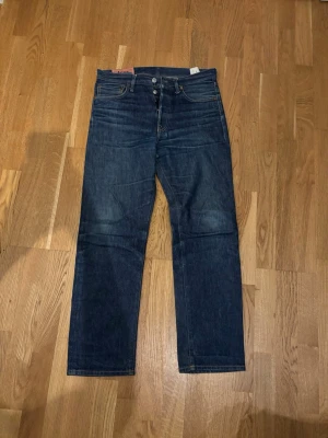 Mörkblå raka jeans med knappar - Snygga jeans från acne studios, modell blåkonst. 30/30 passar något större bra skick små defekter kontakta för dom. Sinnesjuk kvalitet, hör av dig 💬⭐️‼️