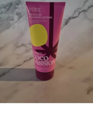 PINK Glowy Coco Passion Brun utan sol - Gradual tanning lotion från PINK i doften Coco Passion. Tuben är rosa med gula och lila detaljer. Innehåller passionsfruktextrakt och sheasmör för återfuktning. Vegansk formula och dermatologiskt testad. Perfekt för en naturlig solkysst look. Helt ny och oanvänd