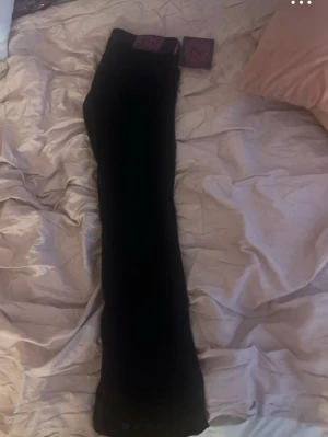 Svarta Cheap Monday jeans - Säljer ett par svarta jeans från Cheap Monday med ikonisk döskalle-logga i lila på bakfickan. Jeansen har en klassisk rak passform och är tillverkade i stretchigt denimtyg för extra komfort. Perfekta för dig som gillar en edgy och stilren look.