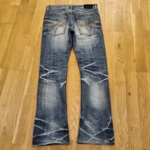 Jack Rose jeans sällsynta  - Säljer ett par helt sjuka Jackrose jeans. Märket är japansk och de är mycket sällsynta. De tros bli mycket populära nu i 2026. De sitter slim men med tydlig bootcut. Brodyren på bakfickan är anmärkningsvärd. Jeansen är i storlek 29 och måtten är: Längd 101 • Midja 40 • Benöppning 20,5. De är knappt använda och är därför i mycket bra skick. Bara att höra av sig vid frågor! Priset är diskuterbart!