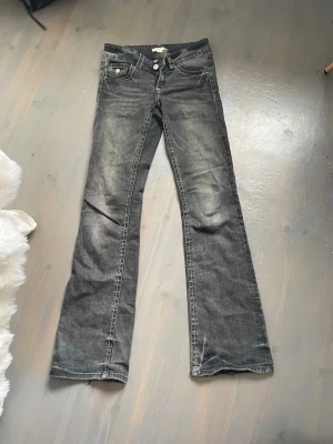 Svarta bootcut jeans - Snygga svarta bootcut jeans med slitningar och tvättad stil. Jeansen har en lätt utsvängd passform och är perfekta för en avslappnad stil. Säljer då de är försmå för mig💕