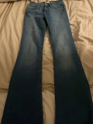 Blå bootcut jeans från ONLY - Säljer ett par blå bootcut jeans från ONLY i storlek XS/32. 
