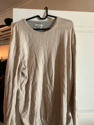 Beige cashmereblandad tröja Hansen & Jacob - Snygg beige stickad tröja från Hansen & Jacob i cashmereblandning. Tröjan har rund halsringning och långa ärmar, perfekt för en stilren och avslappnad look. Enkel design som passar till det mesta.