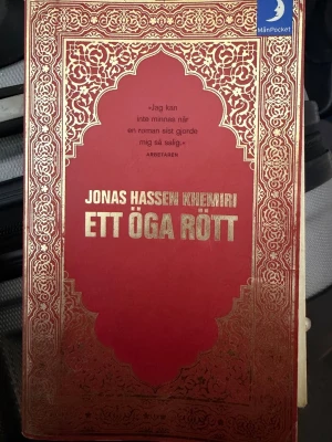 Ett öga rött & No Shame, No Fear - Två skönlitterära pocketböcker: 'Ett öga rött' av Jonas Hassen Khemiri med röd och guld dekorerad framsida, samt 'No Shame, No Fear' av Ann Turnbull med ett konstnärligt omslag i dova färger. Perfekt för dig som gillar starka berättelser och ungdomsromaner.