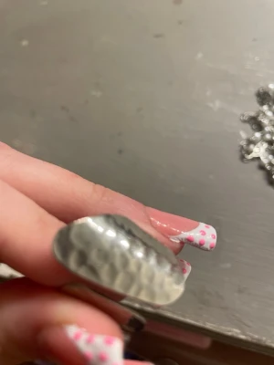 Bred hamrad silverring - Säljer en bred ring i silverfärgat metall med hamrad yta som ger en cool och unik look. Ringen har en öppen design framtill och känns både modern och edgy. Perfekt för dig som vill sticka ut med dina accessoarer.