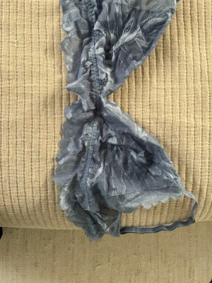 Blå spets-bh med volangkant - Säljer en ljusblå bh i transparent spets från neo noir. Är för stor och kommer ej till användning!