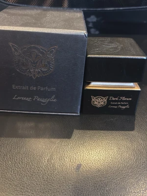 Lorenzo Pazzaglia Dark Florum Parfym - Exklusiv parfym från Lorenzo Pazzaglia, Dark Florum Extrait de Parfum. Flaskan är svart med gulddetaljer och har en elegant, fyrkantig form. Levereras i en lyxig svart ask med guldfärgad logotyp och text. Perfekt för dig som gillar unika och djupa dofter. Storlek: 75 ml och endast testsprutad, doften passar inte mig därför till salu. Pris diskuterbart vid snabb affär